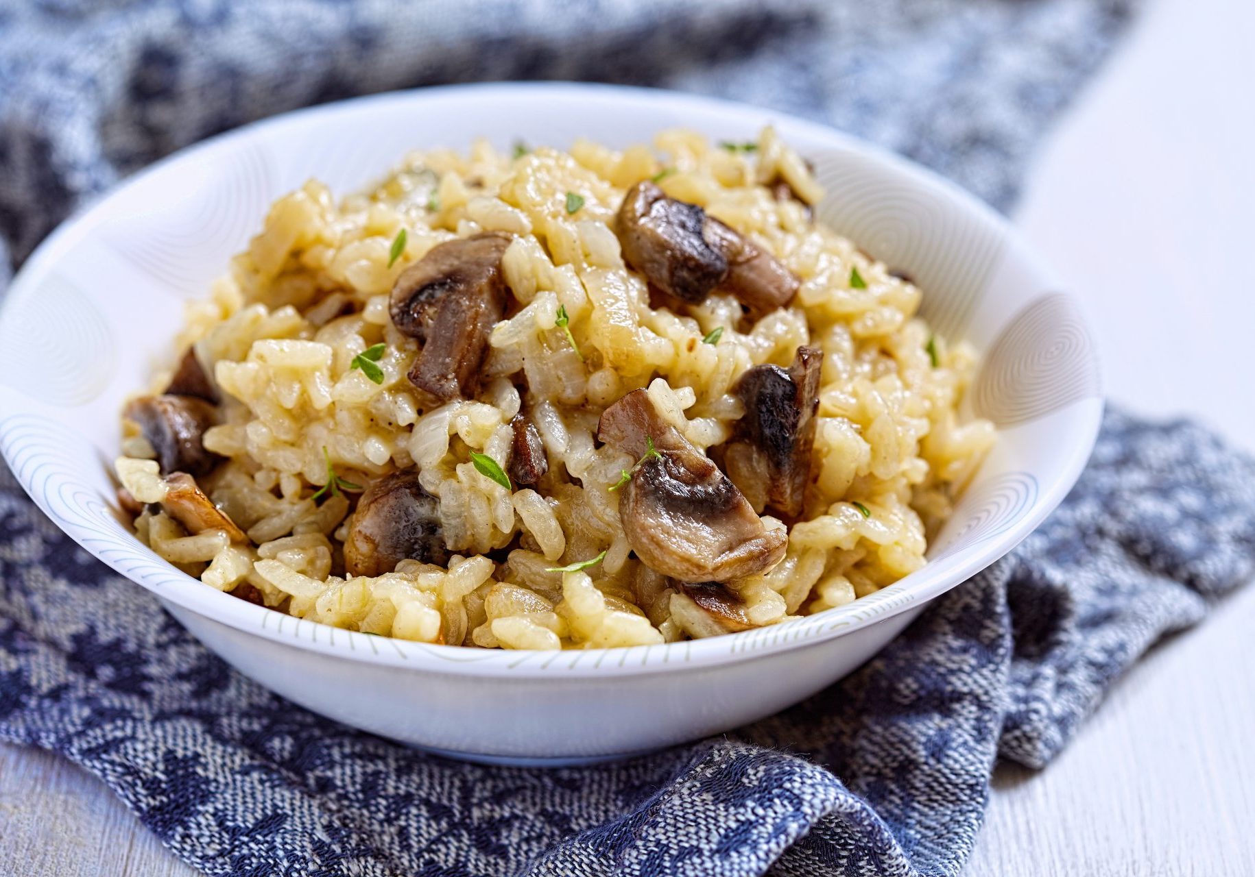 rice with mushrooms in a bowl on a blue napkin