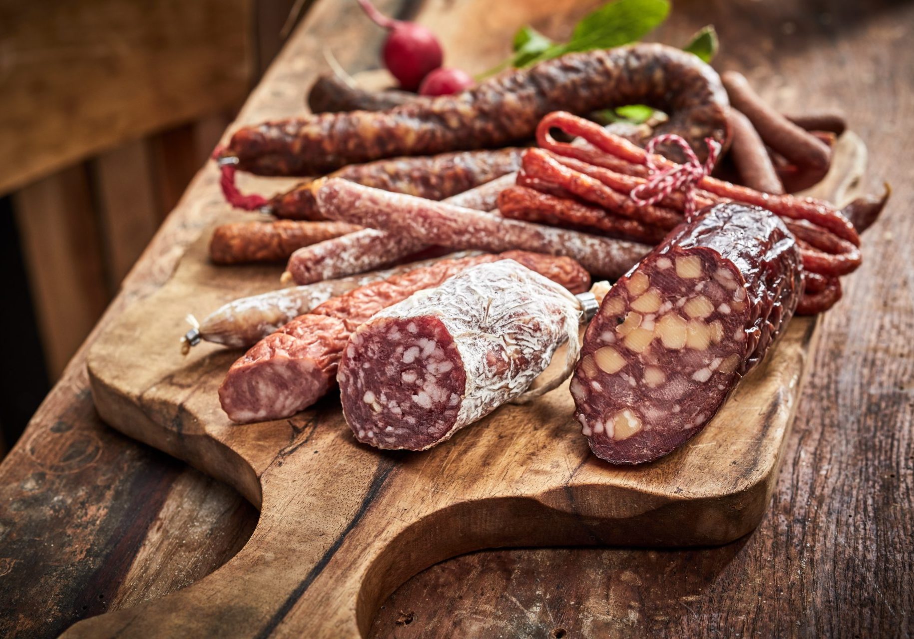 meat and sausages lying on a wooden board