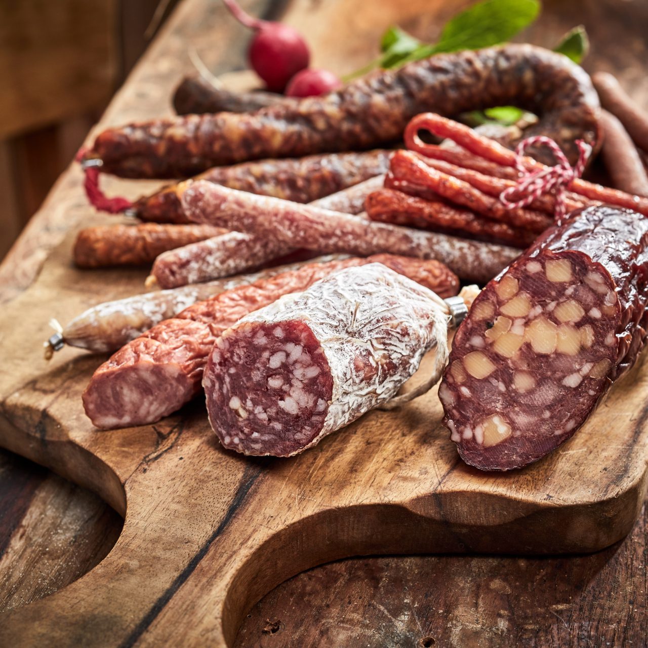 meat and sausages lying on a wooden board