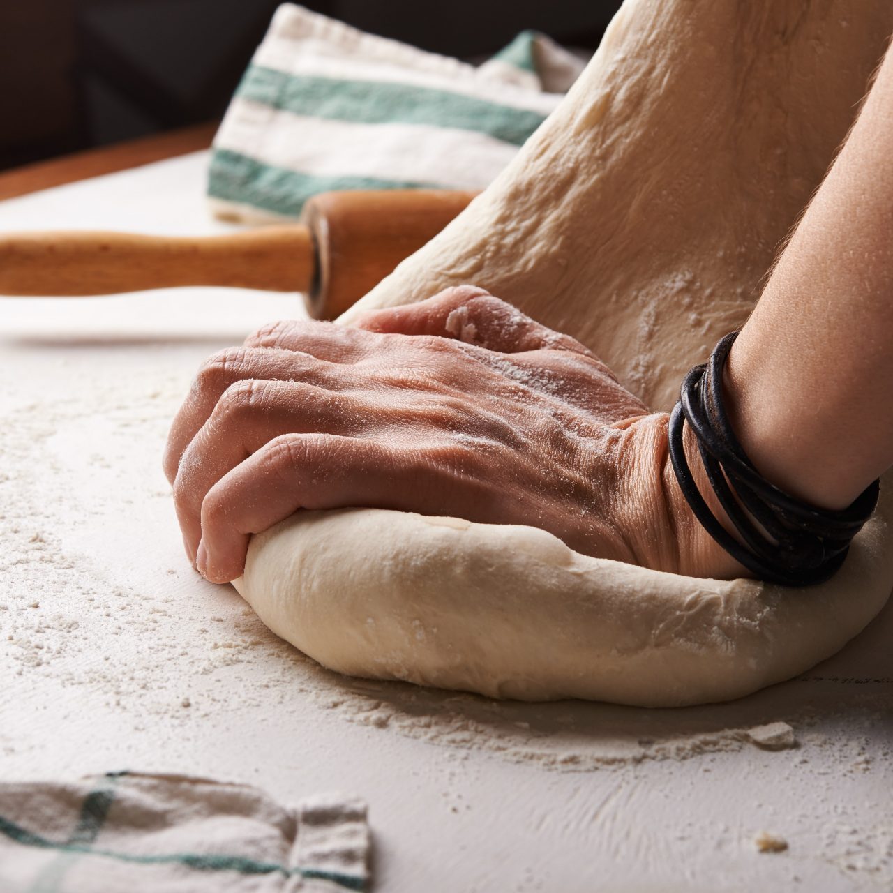 A hand kneading dough on a table