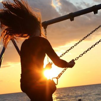 Scelta Inside woman sitting on a swing while the sun is going down sunset health healthy vitamin d