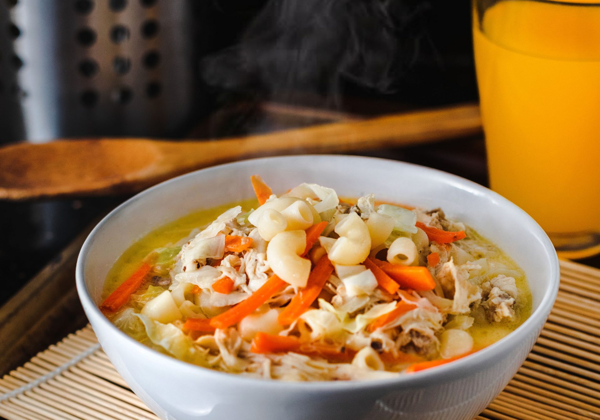 Soup with lots of vegetable and noodles on a table